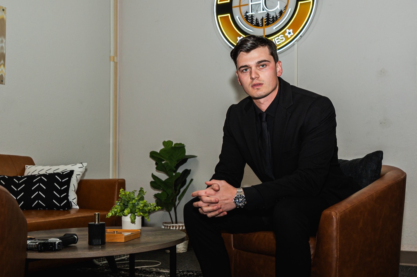 Jared Crist, Founder and CEO, seated in the High Caliber Agencies office under the HC sign